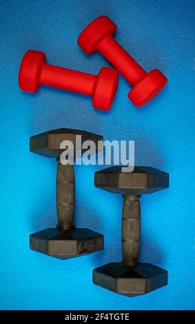 Equipment for exercising the muscles of the hands and arms. A pair of weights on a blue background Stock Photo