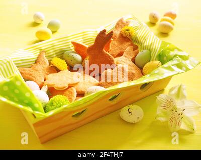 Easter cookies with colored eggs and floewers on yellow green background Stock Photo