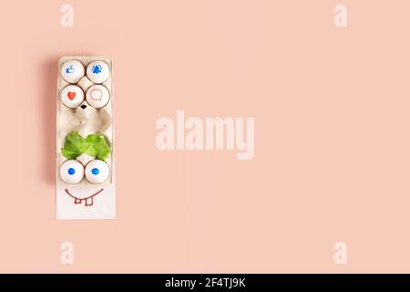 Colorful funny face made of easter eggs on pink background with copy space Stock Photo