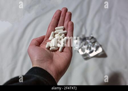 Unknown man committing suicide by overdosing on medication. Close up of overdose pills and addict. Overdose, suicide, depression concept Stock Photo