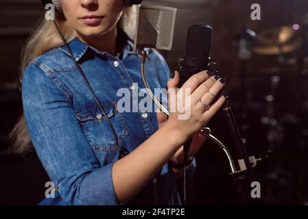 Close up of a singer recording a track in a studio. Stock Photo