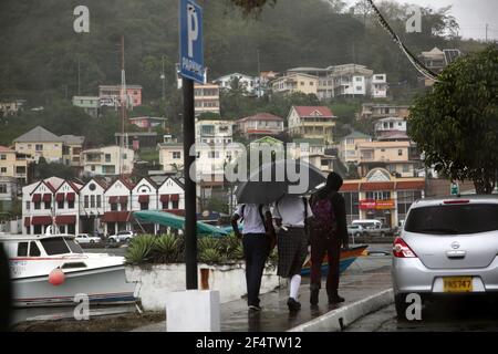 St George Grenada School children walking along the Carenage in the rain Stock Photo