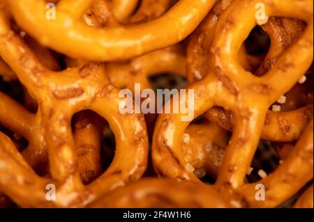 Salted breadsticks and salted pretzels scattered on the table. Close-up selective focus. Stock Photo