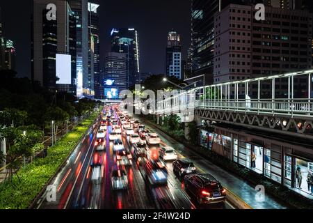 Traffic rushes aong the main avenue in the heart of Jakarta business district in Indonesia capital city at night. Light trails captured with blurred m Stock Photo