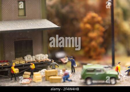 Layout of the city and small figures. A group of workers performs unloading. Stock Photo