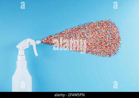 The spray sprays colorful nonpareil balls on a blue background. Isolate, top view. The concept of rainbow and non-standard splashes Stock Photo