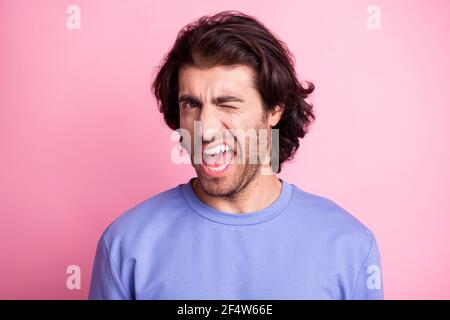 Photo of charming cheerful handsome man wink eye wear purple sweater isolated on pastel shine pastel pink color background Stock Photo