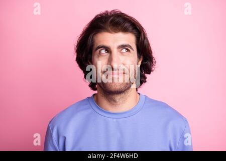 Photo of dreamy inspired young man look think empty space wear violet sweater isolated on pastel pink color background Stock Photo