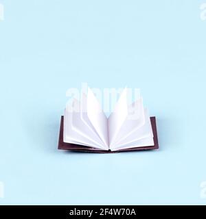 Origami white paper book on blue background Stock Photo