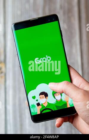 A mobile phone or cell phone being held in a hand with the Grab app open on screen Stock Photo