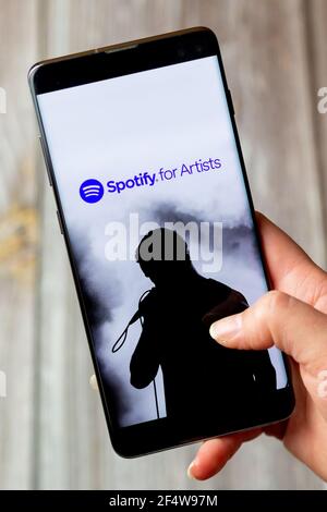 A mobile phone or cell phone being held in a hand with the Spotify for artists app open on screen Stock Photo
