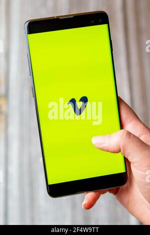 A mobile phone or cell phone being held in a hand with the Vimeo app open on screen Stock Photo