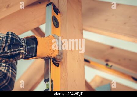 Industrial Theme. Construction Contractor Checking Home Frame Levels Using Sprit Level Tool. Close Up Photo. Stock Photo