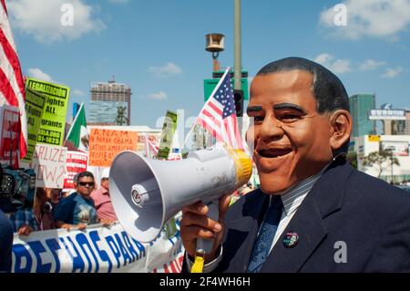 A man wearing a President Obama mask rallies a crowd during an immigration rights protest in Downtown Los Angeles. Stock Photo