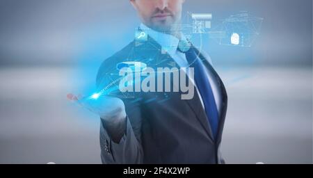 Composition of network of digital icons and data processing over hand of businessman Stock Photo