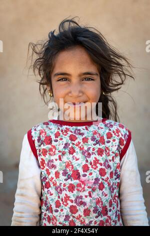 Erg Chebbi, Morocco - April 12, 2016: Portrait of a young girl in front of her home in a village near the Erg Chebbi, in Morocco. Stock Photo