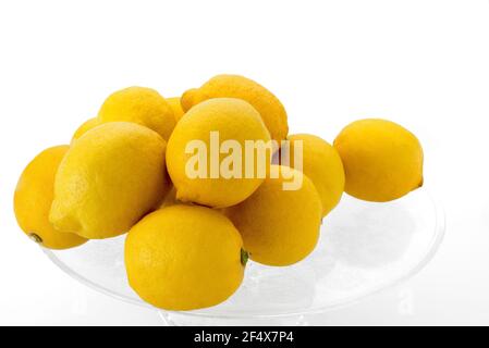 whole lemons on transparent glass plate isolated on white background Stock Photo