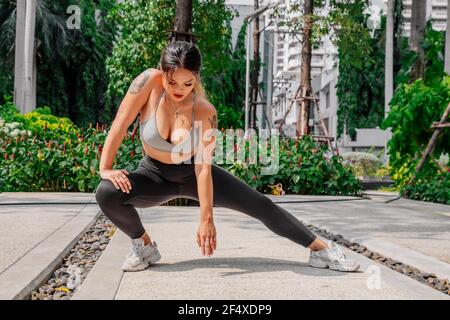 Fit, Sporty person asian young beautiful woman, girl doing yoga pose  planking and physical, training and practice strong on mat in living room.  Workout fitness exercise people in casual wear at home.