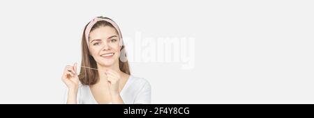 Young woman holding teeth floss. Dental health care concept. Beauty smiling face Stock Photo