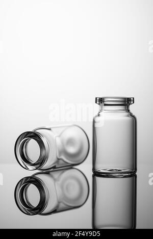 Medicine glass jars, capacity for liquid medicines with an open neck without stopper. Close up shot on a gray background. Stock Photo