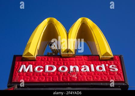 McDonald's light sign with surveillance camera against clear blue sky Stock Photo