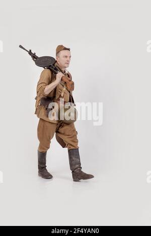 Male actor in the form of ordinary soldiers of the Russian army in the period 1939-1940, with aSelf-loading rifle Tokarev on a white background in the Stock Photo