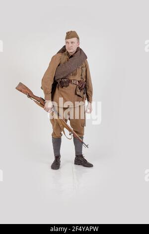 Male actor in the form of ordinary soldiers of the Russian army in the period 1939-1940, with aSelf-loading rifle Tokarev on a white background in the Stock Photo