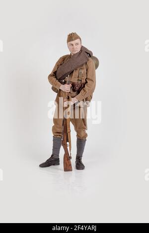 Male actor in the form of ordinary soldiers of the Russian army in the period 1939-1940, with aSelf-loading rifle Tokarev on a white background in the Stock Photo