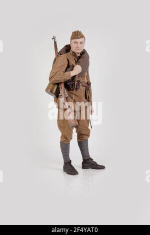 Male actor in the form of ordinary soldiers of the Russian army in the period 1939-1940, with aSelf-loading rifle Tokarev on a white background in the Stock Photo