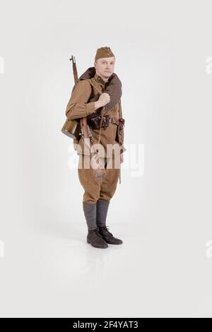 Male actor in the form of ordinary soldiers of the Russian army in the period 1939-1940, with aSelf-loading rifle Tokarev on a white background in the Stock Photo