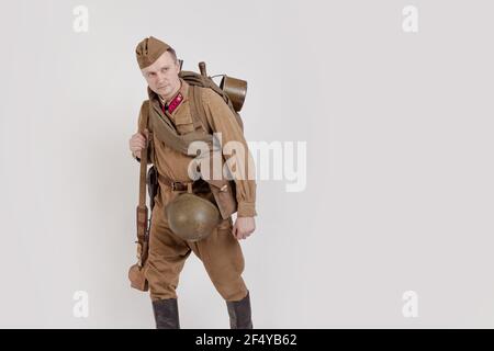 Male actor in the form of ordinary soldiers of the Russian army in the period 1939-1940, with aSelf-loading rifle Tokarev on a white background in the Stock Photo