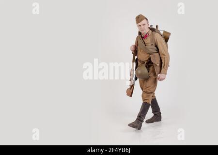 Male actor in the form of ordinary soldiers of the Russian army in the period 1939-1940, with aSelf-loading rifle Tokarev on a white background in the Stock Photo