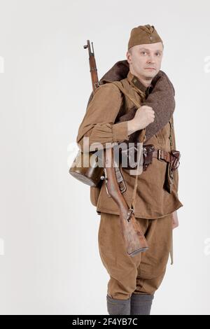 Male actor in the form of ordinary soldiers of the Russian army in the period 1939-1940, with aSelf-loading rifle Tokarev on a white background in the Stock Photo