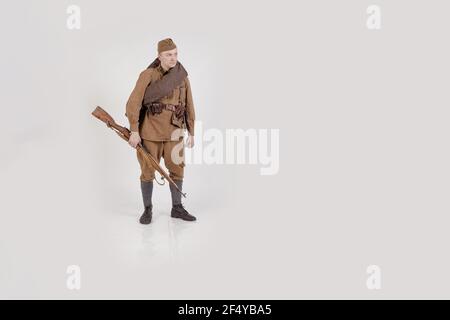 Male actor in the form of ordinary soldiers of the Russian army in the period 1939-1940, with aSelf-loading rifle Tokarev on a white background in the Stock Photo