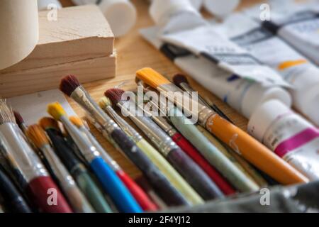 Painting concept. Paintbrushes artists used, dirty and blur tempera tubes on wooden table background. Accessories for hand drawn, art with watercolors Stock Photo