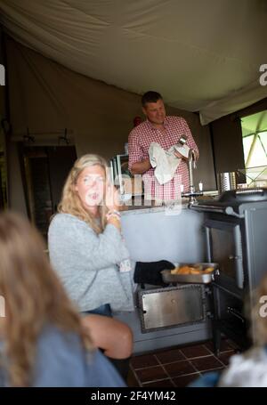 Family cooking and doing dishes in cabin Stock Photo