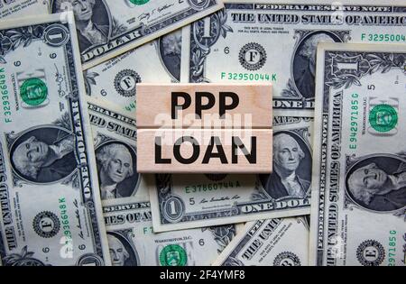 PPP, paycheck protection program loan symbol. Concept words PPP, paycheck protection program loan on wooden blocks on a beautiful background from doll Stock Photo