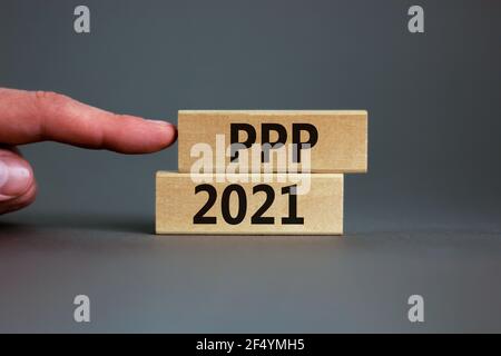 PPP, paycheck protection program 2021 symbol. Concept words PPP, paycheck protection program 2021 on wooden blocks on a beautiful grey backgrounds. Bu Stock Photo