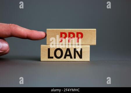 PPP, paycheck protection program loan symbol. Concept words PPP, paycheck protection program loan on wooden blocks on a beautiful grey backgrounds. Bu Stock Photo