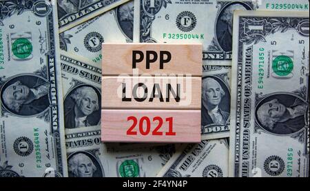 PPP, paycheck protection program loan 2021 symbol. Concept words PPP loan 2021 on blocks on a beautiful background from dollar bills. Business, PPP - Stock Photo