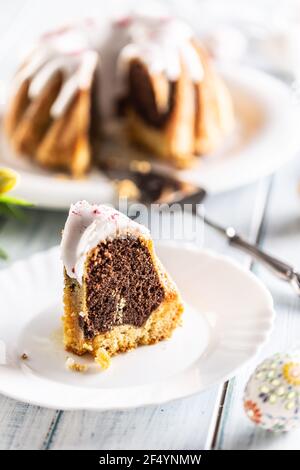 A cut piece of Easter marble cake on a white plate. Stock Photo