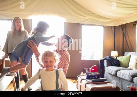Happy family playing in sunny yurt cabin Stock Photo
