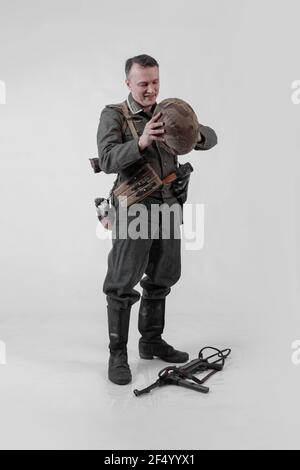 Male actor reenactor in historical military tank uniform as an officer of the German Army during World War II to smoke a cigarette on a white backgrou Stock Photo