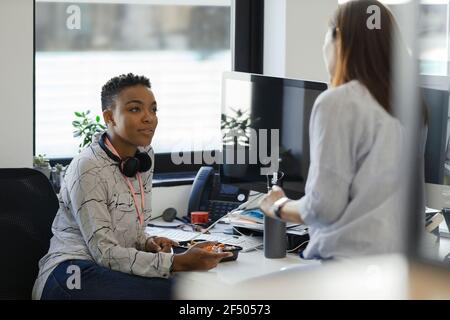 Businesswomen talking at desk in office Stock Photo