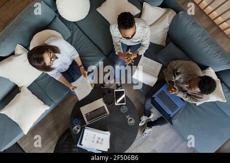 Business people with laptops and paperwork meeting on office sofa Stock Photo