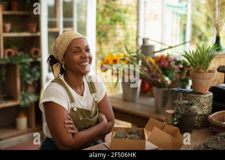 Portrait happy female florist working in shop Stock Photo
