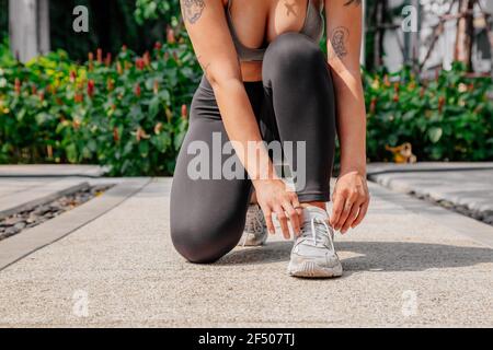 Asian sport girl doing stretching, yoga fitness and plank exercise outside. Fit young thai woman doing training workout in morning. Stock Photo
