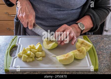 Woman chopping cooking apples to make chutney. Stock Photo