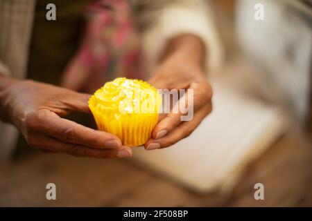 Close up woman holding bright yellow lemon cupcake Stock Photo