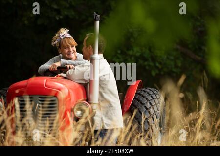 Happy couple at tractor in orchard Stock Photo